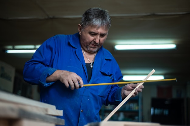 Charpentier Au Travail En Atelier, Un Homme Fait Des Mesures