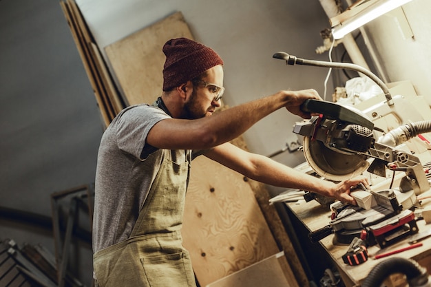 Charpentier, couper du bois en atelier