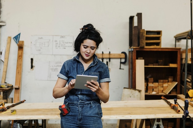 Charpentier féminin à l'aide d'une tablette