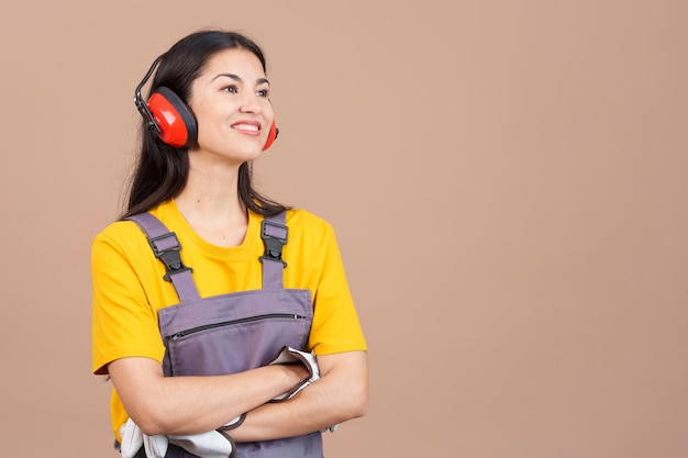 Charpentier féminin distrait regardant loin avec les bras croisés