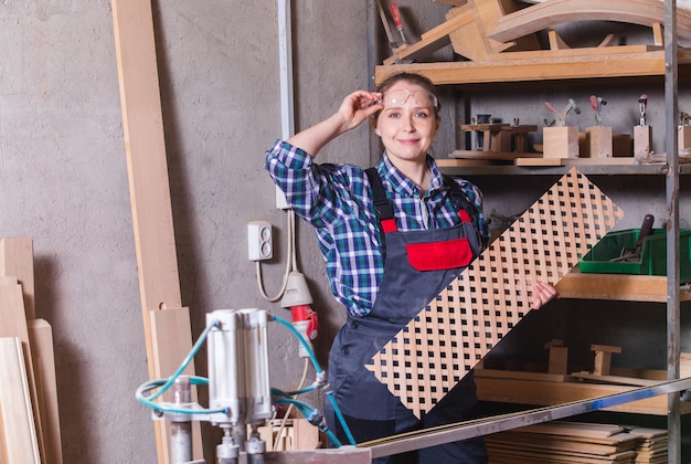 Charpentier féminin avec grille en bois près de la scie circulaire