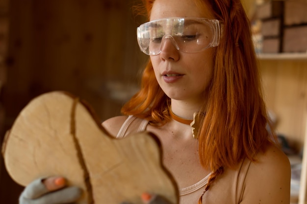 charpentier féminin travaillant avec du bois dans l'atelier