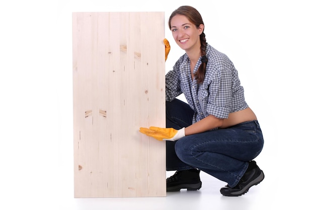 Charpentier femme tenant une planche de bois