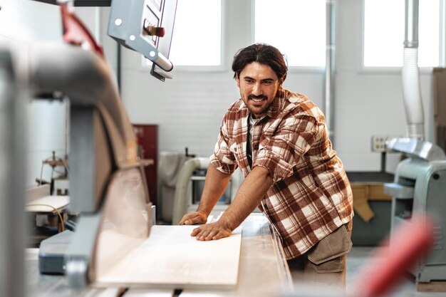 Charpentier masculin utilisant des outils de menuiserie pour son travail dans une usine