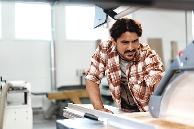 Charpentier masculin utilisant des outils de menuiserie pour son travail dans une usine