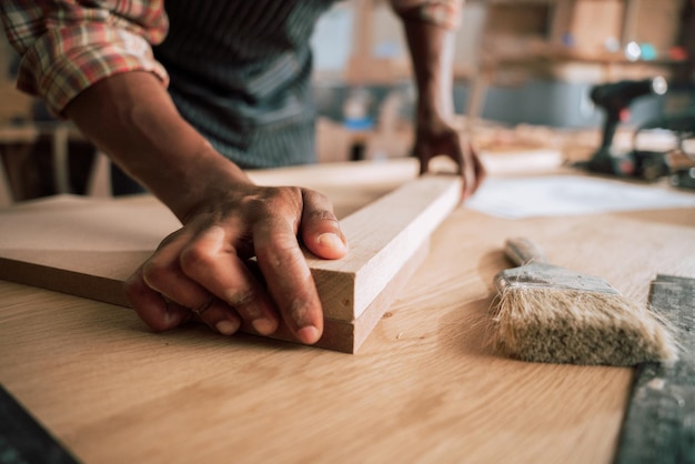 Charpentier mesurant et traitant le bois sur une table de travail en atelier