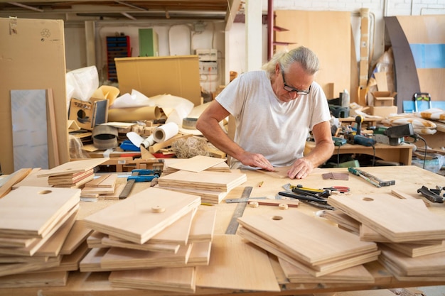 Charpentier travaillant dans un espace de travail produisant des objets artisanaux en bois faits à la main