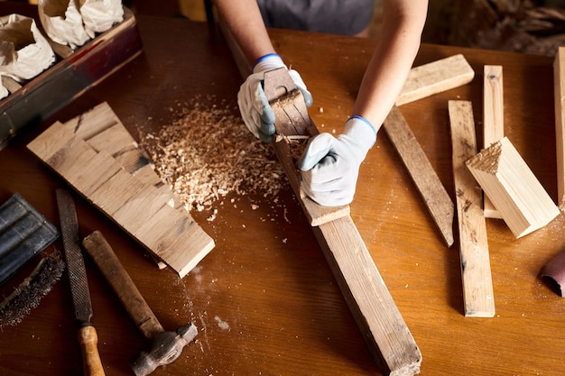 Charpentier travaillant avec du matériel sur une table en bois dans un atelier de menuiserie. femme travaille dans un atelier de menuiserie.