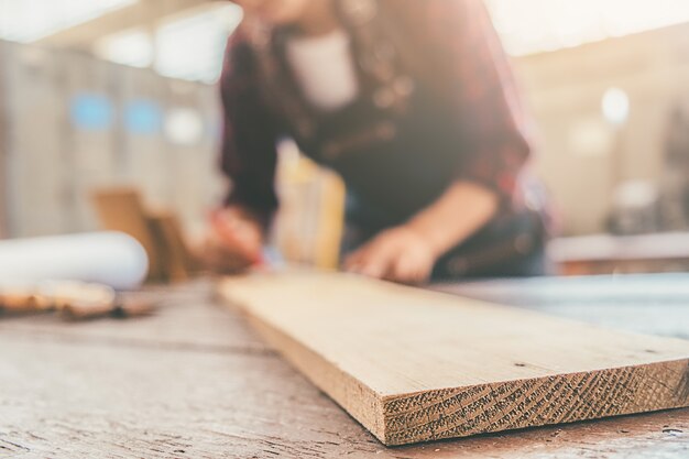 Charpentier travaillant avec de l&#39;équipement sur une table en bois dans un atelier de menuiserie