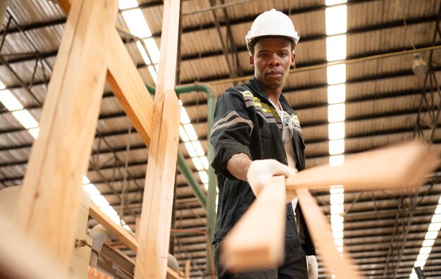 Photo un charpentier travaille dans une usine de bois rassemblez le bois qui est passé par le coupeur de bois en petits