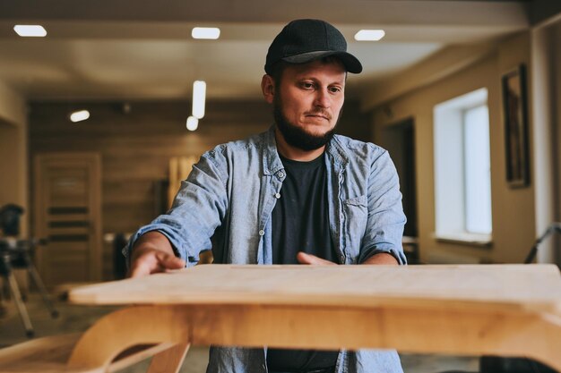 Charpentier travaille avec du bois dans un atelier de menuiserie