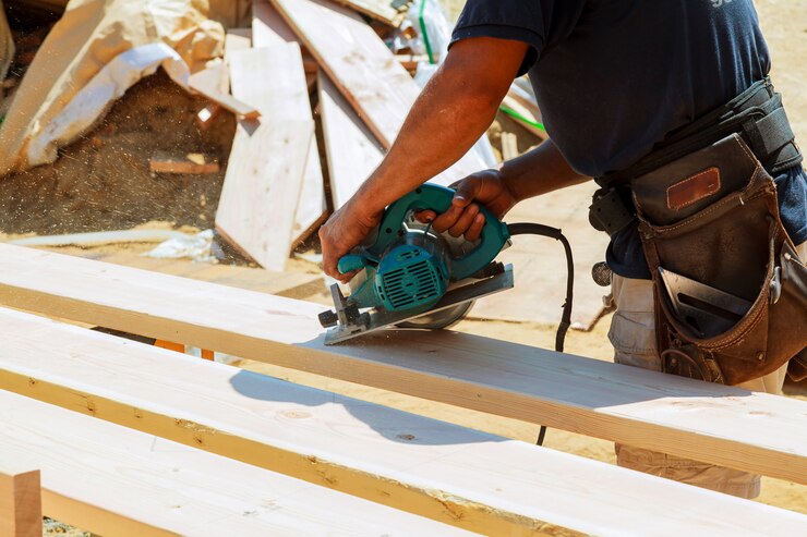 Photo charpentier utilisant une scie circulaire pour couper des planches en bois. détails de construction d&#39;un ouvrier