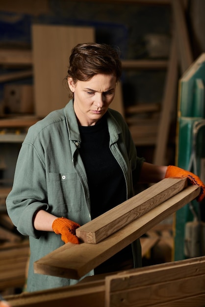 Une charpentière dévouée fabrique méticuleusement des morceaux de bois dans un atelier animé