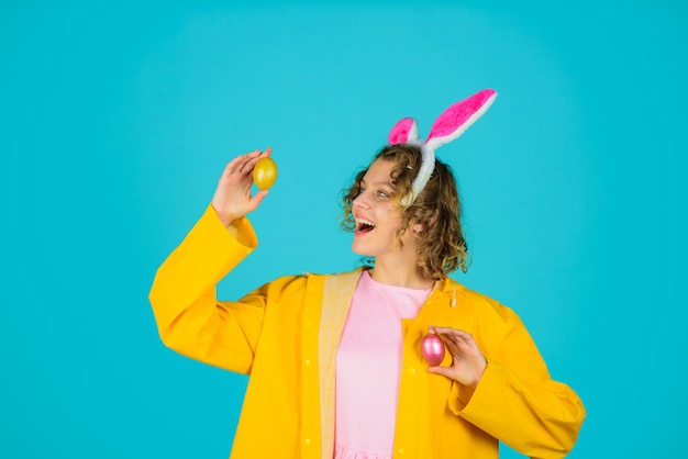 Chasse aux œufs joyeuses pâques chasse aux œufs femme avec des oreilles de lapin tient un œuf de pâques femme dans des oreilles de lapin tient