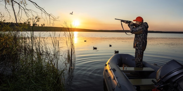 Chasseur avec une arme à feu chassant les canards en bannière de saison d'automne avec espace de copie