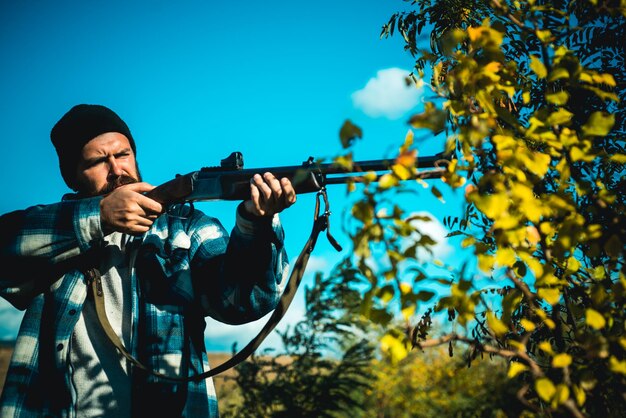 Chasseur avec fusil de chasse à la chasse. Homme tenant un fusil de chasse.