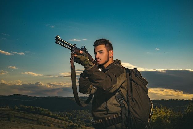 Chasseur avec fusil de chasse à la chasse. Matériel de chasse à vendre. Chasseur visant le fusil en forêt. Chasse en montagne.