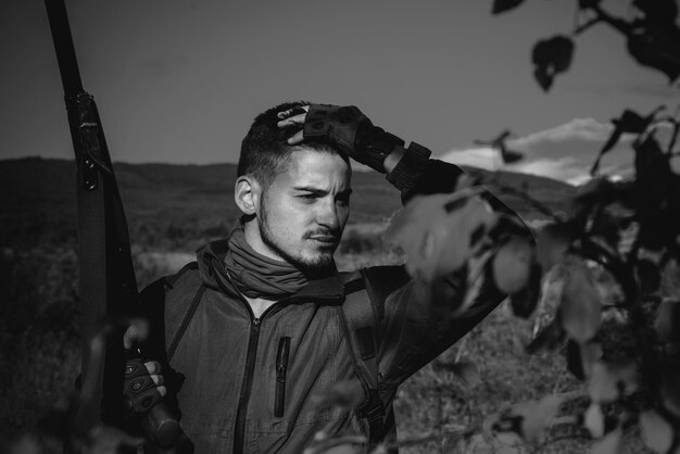 Chasseur avec fusil de chasse sur chasse portrait de chasse en montagne de chasseur hamdsome