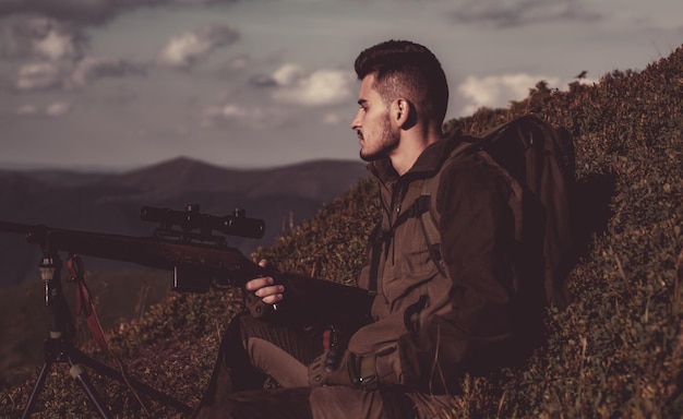 Chasseur avec un fusil de chasse dans la forêt d'automne chassant en amérique chassant dans la forêt de printemps