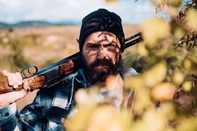 Chasseur avec fusil de chasse sur l'homme de chasse tenant un fusil de chasse