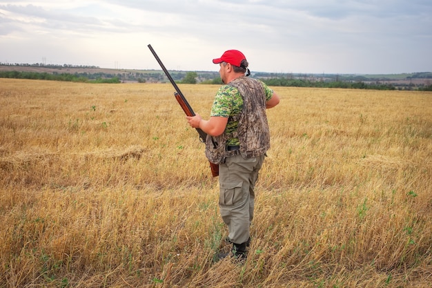 Chasseur avec fusil de chasse à la recherche de proies.