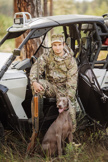 Chasseur avec fusil et pneu à quatre roues en forêt