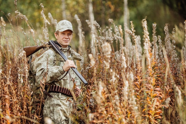 Chasseur d'homme avec fusil de chasse en forêt