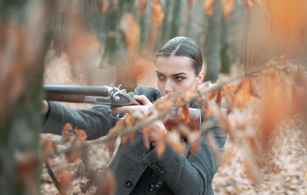 Chasseur observant la chasseuse de la forêt dans la forêt chasse réussie chasse sport femme avec arme targ