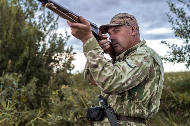 Chasseur en uniforme avec un fusil de chasse. Chasse