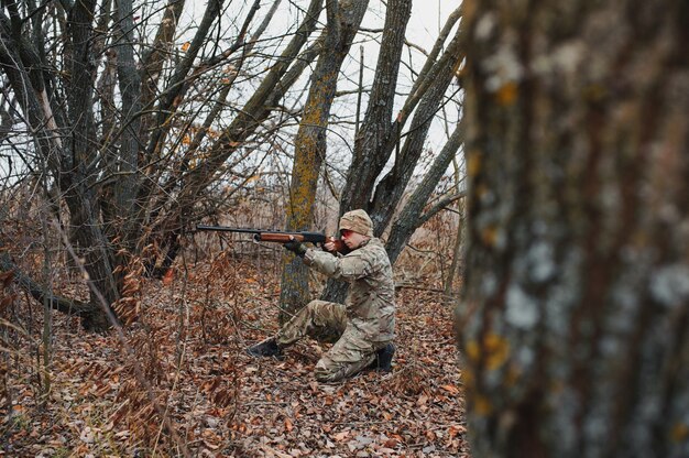 Chasseur en uniforme avec un fusil de chasse