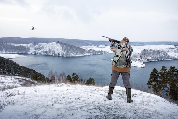 Chasseur visant la chasse à l'oiseau sur le tétras lyre en hiver