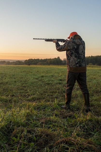 Photo chasseur visant avec un fusil sur un faisan