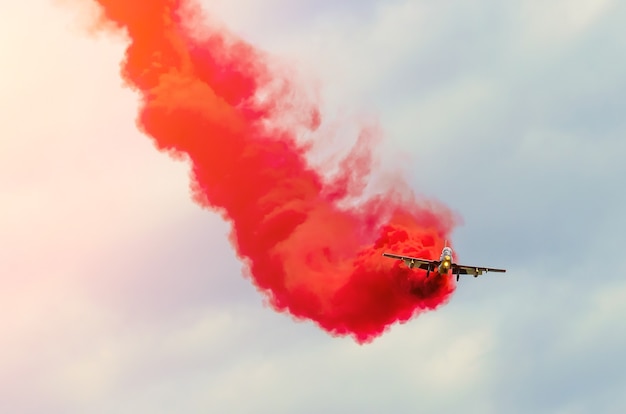 Les chasseurs d'avions de l'équipe de voltige traînent de la fumée rouge dans le ciel.