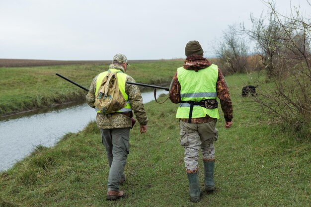 Chasseurs avec un drathaar et un épagneul allemands, chasse au pigeon avec des chiens en gilets réfléchissants