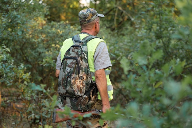 Chasseurs de faisan avec fusil de chasse marchant dans un pré.