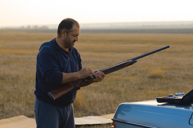 Chasseurs de faisans avec fusil de chasse marchant dans un pré.