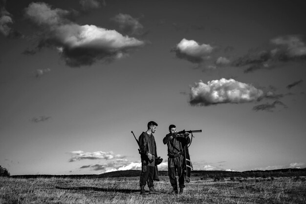 Chasseurs avec fusil de chasse à la chasse chasseur homme tenant un pistolet et marchant dans la forêt