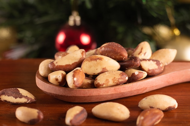 Châtaignes dans une cuillère en bois sur un fond de Noël