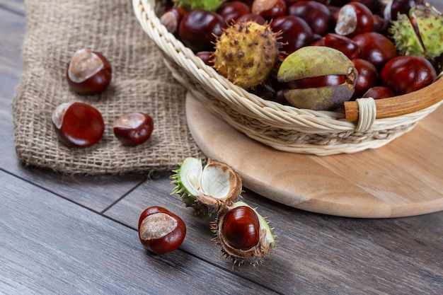 Châtaignes dans un panier sur un fond en bois.