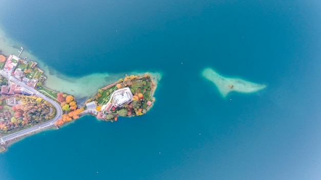 Château et forêt au milieu de l'eau dans un lac dans les Alpes vue d'en haut