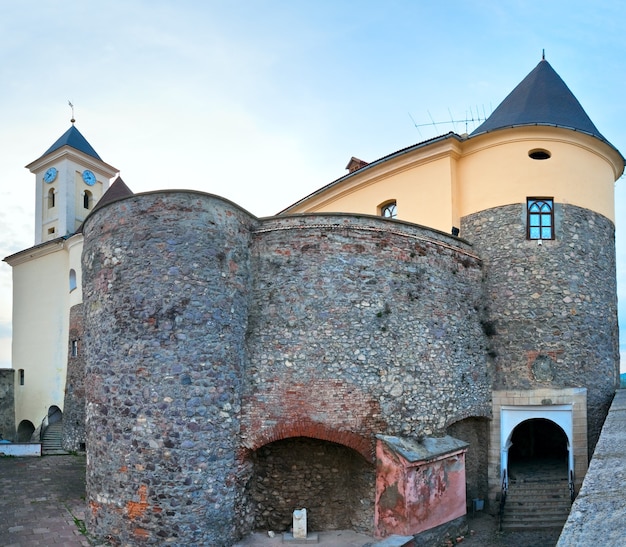 Photo château historique de palanok dans la ville de moukatchevo (région de zakarpattja, ukraine). construit au 14ème siècle. deux clichés piquent l'image.
