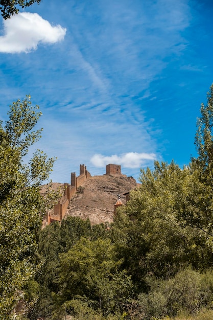 Château et mur du village espagnol historique d'albarracin qui surplombe les arbres