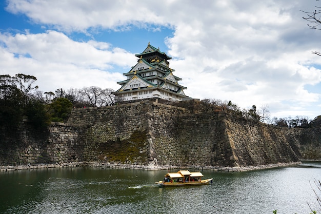 Photo le château d'osaka à osaka, au japon, avec une promenade touristique en bateau autour du château d'osaka