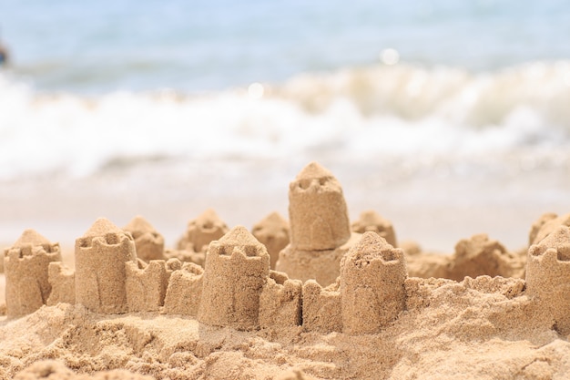 Château de sable debout sur la plage.