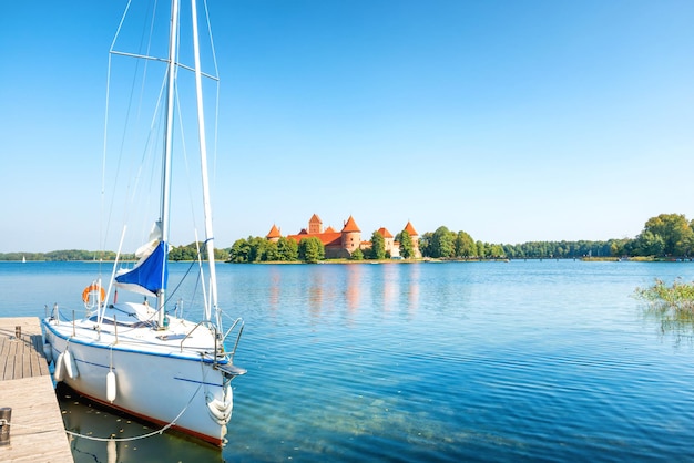 Château de Trakai sur le lac de l'île avec yacht blanc en Lituanie