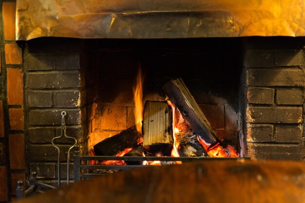 chauffage au poêle et concept d'incendie - gros plan d'une cheminée en feu à la maison