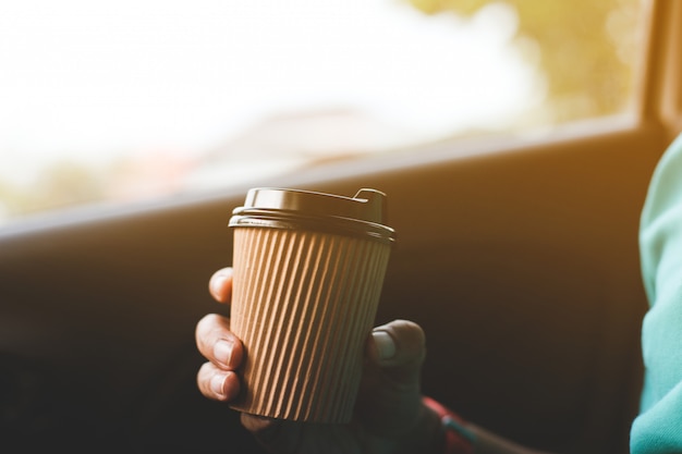 Un chauffeur boit du café dans la voiture.