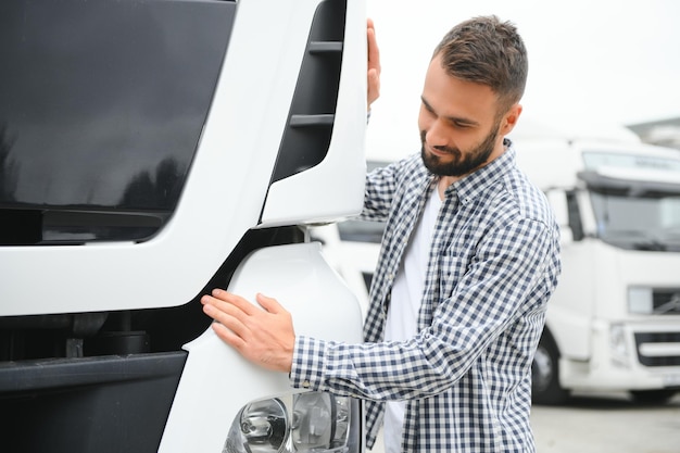 Un chauffeur de camion aime son travail. Un chauffeur de camion professionnel embrasse la cabine de son camion et aime son travail.