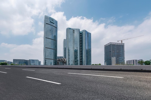 Chaussée d'asphalte et skyline de construction urbaine