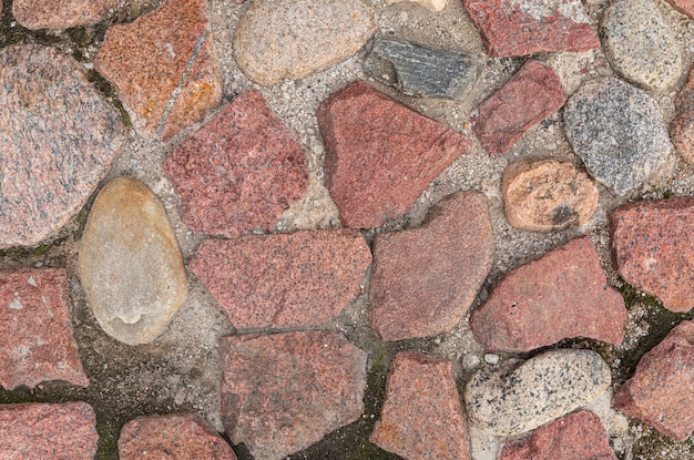 Chaussée de pierres de granit principalement rouge, motif transparent, texture